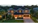 Two-story home with red door, attached garage, manicured lawn, and neatly trimmed hedges at twilight at 6302 Anise Dr, Sarasota, FL 34238