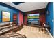 Blue media room with a large flat screen tv, brown leather couch, and guitar at 6302 Anise Dr, Sarasota, FL 34238