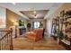 Open-concept living room with wood flooring, a cozy chair, and seamless flow to the staircase at 6302 Anise Dr, Sarasota, FL 34238