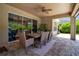 Covered patio has a dining table, ceiling fan, and sliding glass doors to the home's interior at 6302 Anise Dr, Sarasota, FL 34238