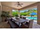 Covered patio with bench and a wooden table overlooks the pool and landscaped backyard at 6302 Anise Dr, Sarasota, FL 34238