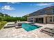 Backyard pool and spa area featuring stylish brickwork, sun loungers, and a covered outdoor dining space at 6302 Anise Dr, Sarasota, FL 34238