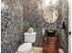 Elegant powder room featuring unique mosaic tiles, a decorative mirror, and a stylish vessel sink at 6302 Anise Dr, Sarasota, FL 34238