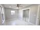 A bedroom with white marble floors, a ceiling fan, and mirrored closet doors at 6404 8Th Street W Ct, Bradenton, FL 34207