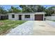 Charming single-story home with a gray paver driveway and a one-car garage at 6404 8Th Street W Ct, Bradenton, FL 34207