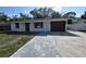 Charming single-story home with a gray paver driveway and a one-car garage at 6404 8Th Street W Ct, Bradenton, FL 34207