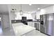Modern kitchen with white cabinets, quartz countertops, stainless steel appliances and gray backsplash at 6404 8Th Street W Ct, Bradenton, FL 34207