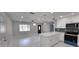 Open concept living room with white marble floors, white cabinets, and stainless steel appliances at 6404 8Th Street W Ct, Bradenton, FL 34207