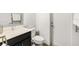 A secondary bathroom with a vanity featuring a marble countertop, as well as modern toilet and door at 650 Rosemary Cir, Bradenton, FL 34212