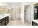 Modern bathroom featuring a glass-enclosed shower, double vanity, and access to a walk-in closet at 650 Rosemary Cir, Bradenton, FL 34212