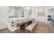 Bright dining room with rustic-wood table, white chairs, contemporary chandeliers, and tiled floors at 650 Rosemary Cir, Bradenton, FL 34212