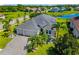 This gorgeous exterior elevation features an enormous roof, three-car garage, and lush landscaping with a lake view at 650 Rosemary Cir, Bradenton, FL 34212