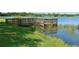 The wooden fishing pier in the lake is well maintained with grass and trees surrounding it at 650 Rosemary Cir, Bradenton, FL 34212