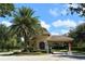 Community entrance gate featuring lush landscaping, mature palm trees and a private entry at 650 Rosemary Cir, Bradenton, FL 34212