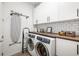 Bright laundry room with modern appliances, white cabinetry, subway tile backsplash, and butcher block countertop at 650 Rosemary Cir, Bradenton, FL 34212