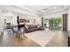 Spacious living room with neutral decor, wood-look tile, and sliding glass doors to the lanai at 650 Rosemary Cir, Bradenton, FL 34212