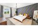 Stylish main bedroom with a statement wall, a large window, and a contemporary light fixture at 650 Rosemary Cir, Bradenton, FL 34212