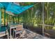 Charming outdoor dining area with a screened enclosure and tropical foliage at 650 Rosemary Cir, Bradenton, FL 34212