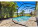 Inviting pool with screened enclosure, overlooking lush landscaping and a serene lake view at 650 Rosemary Cir, Bradenton, FL 34212