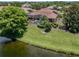 Aerial view of backyard with lush lawn, screened pool, and lake in a tranquil setting at 673 Crane Prairie Way, Osprey, FL 34229