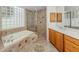 Bathroom featuring a tiled shower and soaking tub near a vanity with neutral colored cabinets at 673 Crane Prairie Way, Osprey, FL 34229