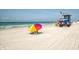A beautiful sandy beach featuring an umbrella, lifeguard station, and clear blue ocean water at 673 Crane Prairie Way, Osprey, FL 34229