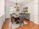 Dining room features hardwood floors, decorative chandelier, natural light, and a modern style sideboard at 673 Crane Prairie Way, Osprey, FL 34229