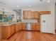 Kitchen with wooden cabinetry, granite countertops, stainless steel appliances and hardwood floors at 673 Crane Prairie Way, Osprey, FL 34229