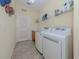 Bright laundry room with modern washer and dryer, plus shelving for storage, and a utility sink at 673 Crane Prairie Way, Osprey, FL 34229