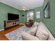Cozy living room featuring hardwood floors, green walls, and a comfortable sofa near a bright window at 673 Crane Prairie Way, Osprey, FL 34229