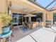 Covered outdoor patio featuring a dining set, grill, and views of the yard and pool at 673 Crane Prairie Way, Osprey, FL 34229