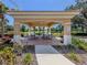 Community picnic shelter with tables, a fan, and views of a pond surrounded by manicured landscaping at 673 Crane Prairie Way, Osprey, FL 34229