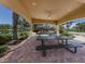 Shaded picnic area with tables, ceiling fan, and view of playground and lake in a beautiful landscaped neighborhood at 673 Crane Prairie Way, Osprey, FL 34229