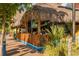 Charming tiki bar with thatched roof and bamboo accents, set along a brick walkway at 673 Crane Prairie Way, Osprey, FL 34229