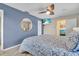 Bedroom with a ceiling fan, TV, and a round mirror on the blue accent wall at 6731 Washington Pl, Bradenton, FL 34207