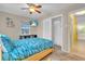 Comfortable bedroom with ceiling fan, mounted television, closet with sliding doors and sunny yellow hallway at 6731 Washington Pl, Bradenton, FL 34207