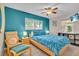 Bright bedroom featuring a ceiling fan, matching blue bedspread and accent wall, plus a chair for relaxing at 6731 Washington Pl, Bradenton, FL 34207