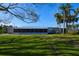 Exterior view of the home with metal roof, screened in porch, and verdant lawn at 6731 Washington Pl, Bradenton, FL 34207