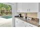 Kitchen area with granite countertop and view of pool through sliding glass doors at 6731 Washington Pl, Bradenton, FL 34207