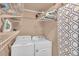 Functional laundry room with washer, dryer, shelving, ironing board and storage space at 6731 Washington Pl, Bradenton, FL 34207