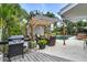Outdoor pergola with seating next to the pool with a grill and hot tub nearby at 6731 Washington Pl, Bradenton, FL 34207