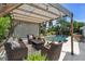 Outdoor pergola featuring cozy wicker seating and a view of the pool and hot tub at 6731 Washington Pl, Bradenton, FL 34207