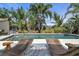 Backyard pool with sun loungers and lush tropical landscaping at 6731 Washington Pl, Bradenton, FL 34207