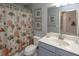 Well-lit bathroom with a vanity, toilet, and a shower with a nautical-themed shower curtain at 7005 River Hammock Dr # 303, Bradenton, FL 34212