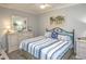 Bedroom with beach theme, large mirror, queen bed and bedside table at 7005 River Hammock Dr # 303, Bradenton, FL 34212