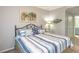 Bedroom featuring palm tree art, patterned bedding, and a coastal theme at 7005 River Hammock Dr # 303, Bradenton, FL 34212