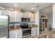 Kitchen with stainless steel appliances, light cabinets, and granite countertops with decorative accents at 7005 River Hammock Dr # 303, Bradenton, FL 34212