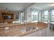 Kitchen with granite countertops, bar seating, and view into the living room and outdoor balcony at 7005 River Hammock Dr # 303, Bradenton, FL 34212