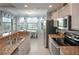 Bright kitchen with granite countertops, stainless steel appliances, and a breakfast nook overlooking a scenic view at 7005 River Hammock Dr # 303, Bradenton, FL 34212