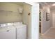 Laundry room featuring a white washer and dryer, a wire shelf, and an adjacent doorway at 7005 River Hammock Dr # 303, Bradenton, FL 34212
